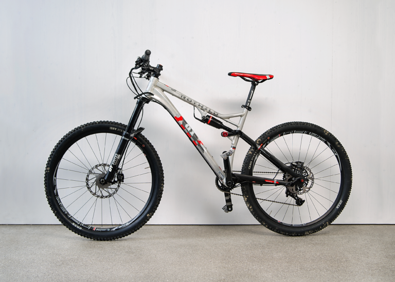 Full-suspension mountain bike with disc brakes, photographed against a neutral background